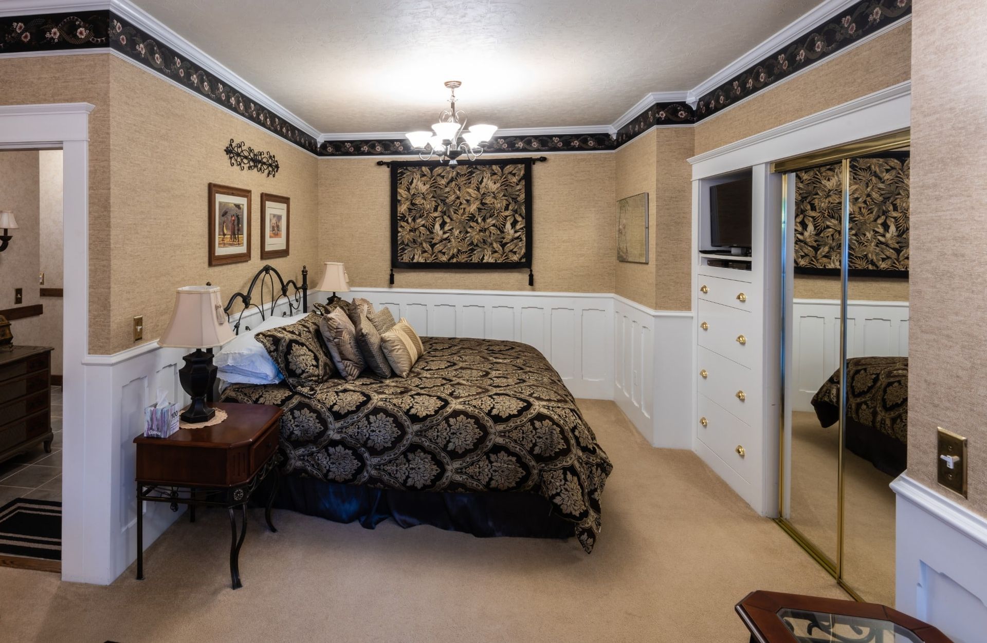 A bedroom with a king size bed and a mirrored closet