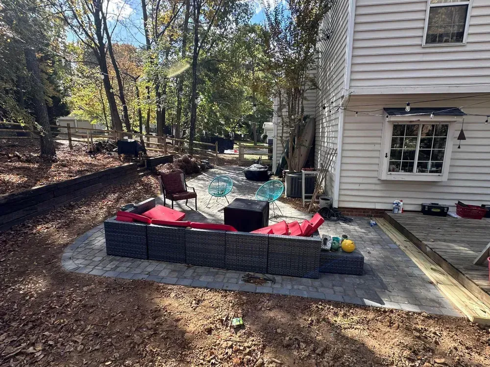 A patio with a couch and chairs in front of a house.