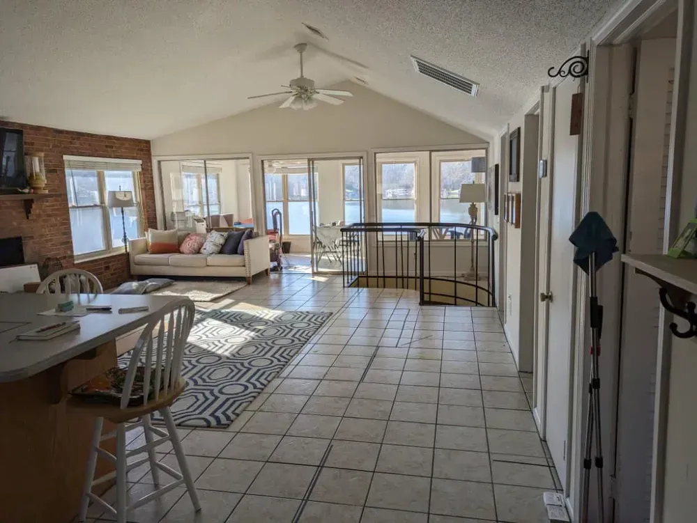 A living room with a couch , table , chairs and a ceiling fan.