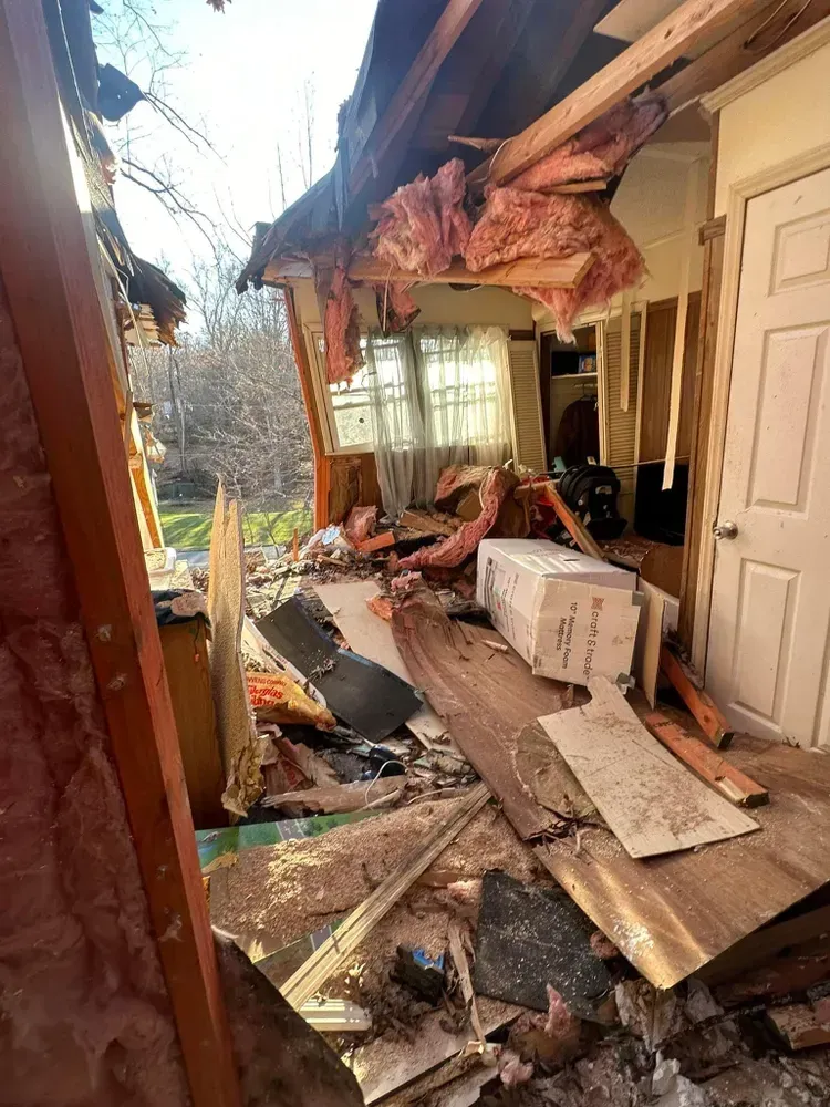 Damage inside a building, with exposed insulation and debris.