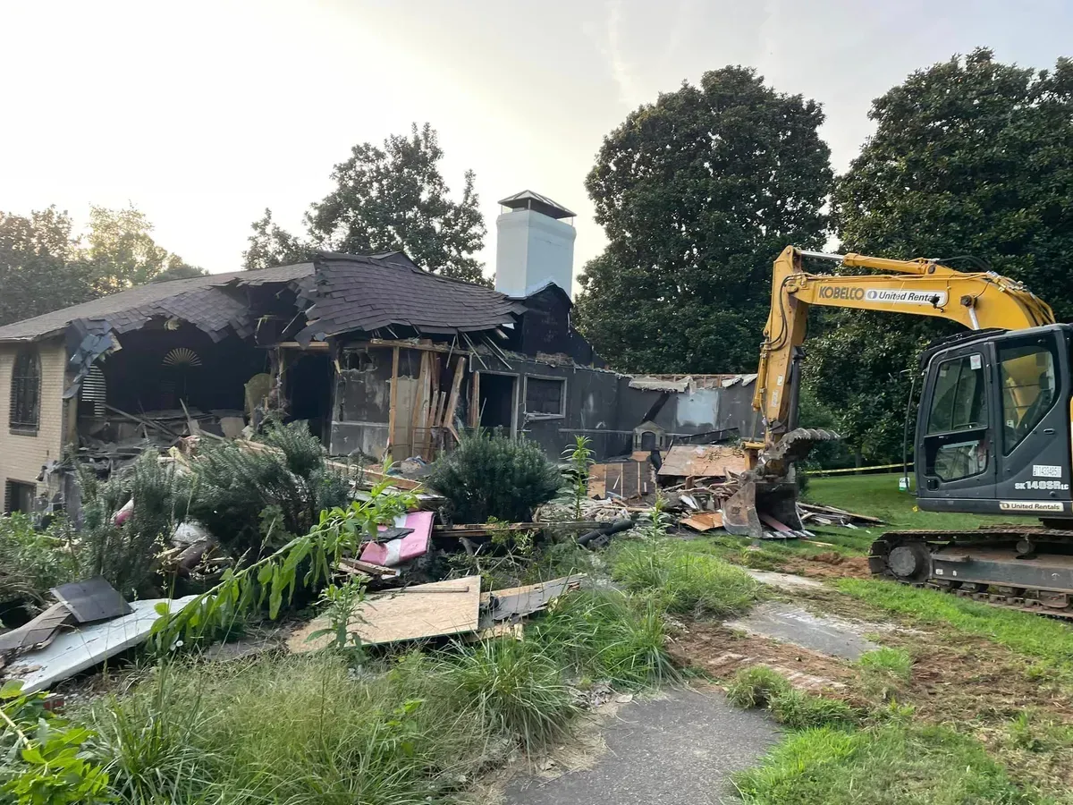 A house is being demolished by a bulldozer.