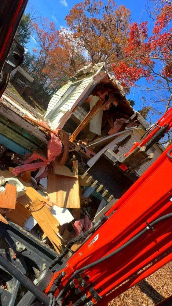 A house is being demolished by a bulldozer.