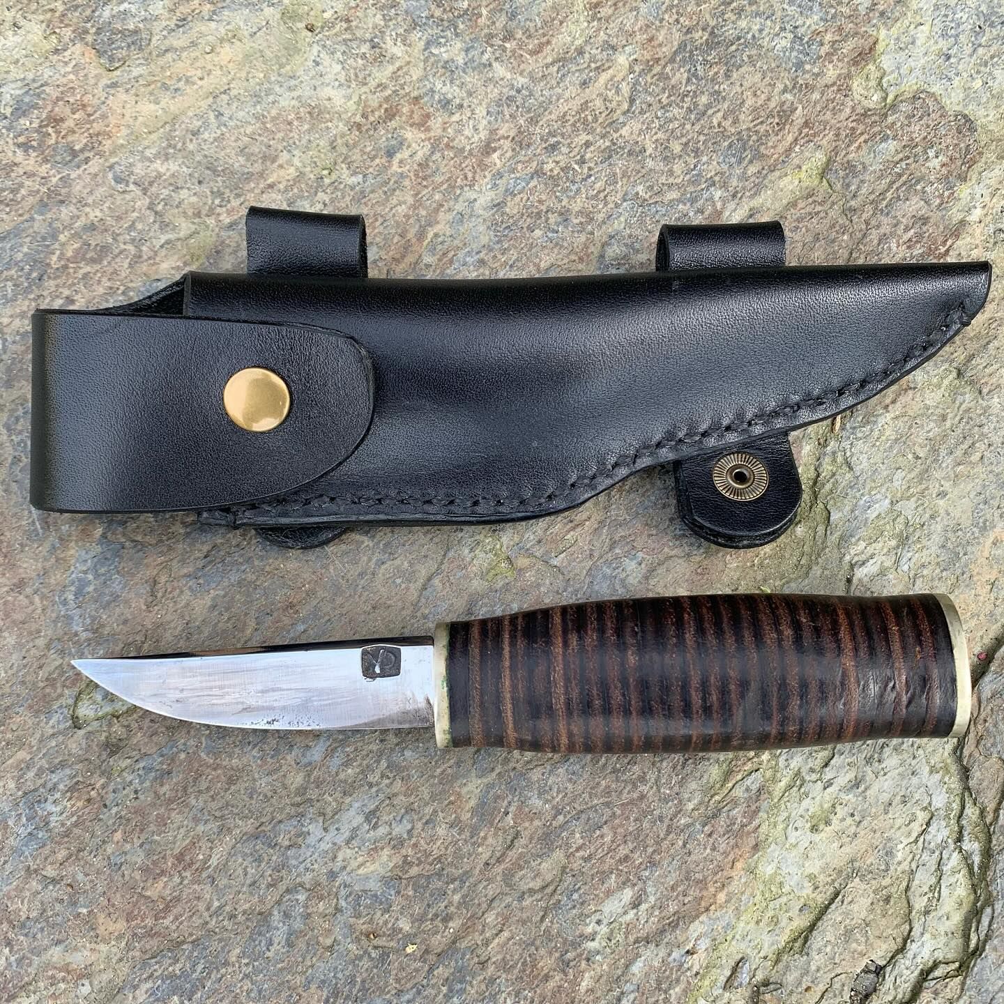 Sharpened knife with a black leather protector