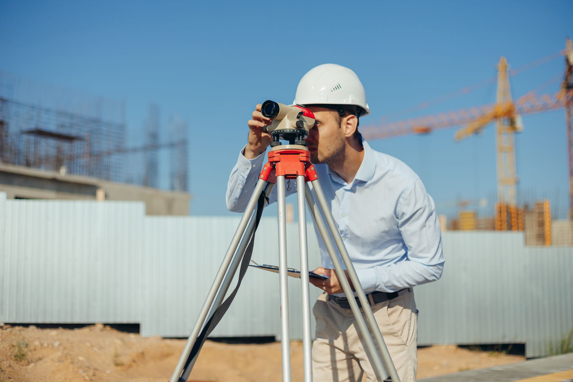 A man is using a leveling instrument. A man is using a leveling instrument.