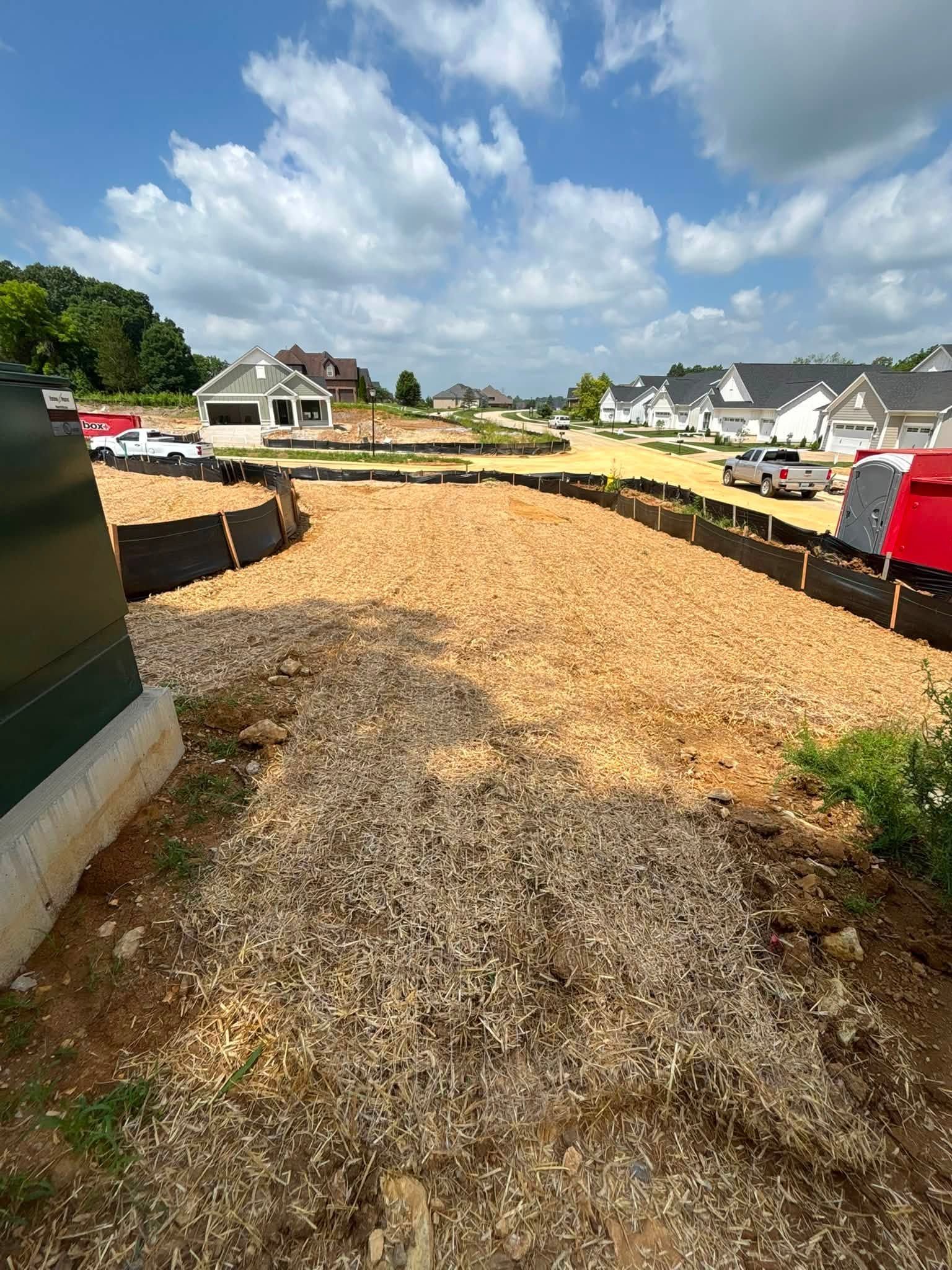 New gravel driveway under construction in a suburban neighborhood on a sunny day