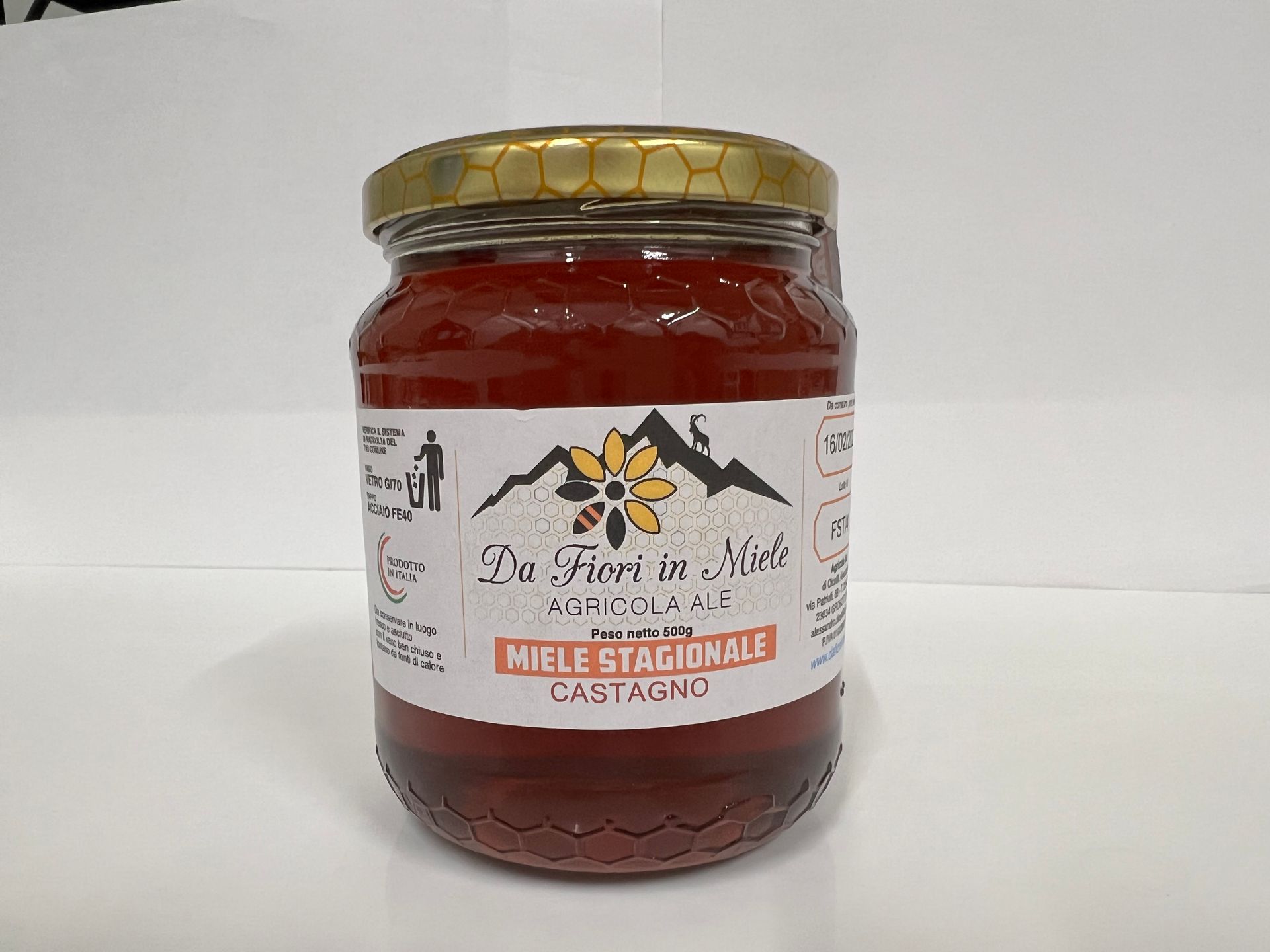 Barattolo di miele di castagno con etichetta, su superficie bianca.
