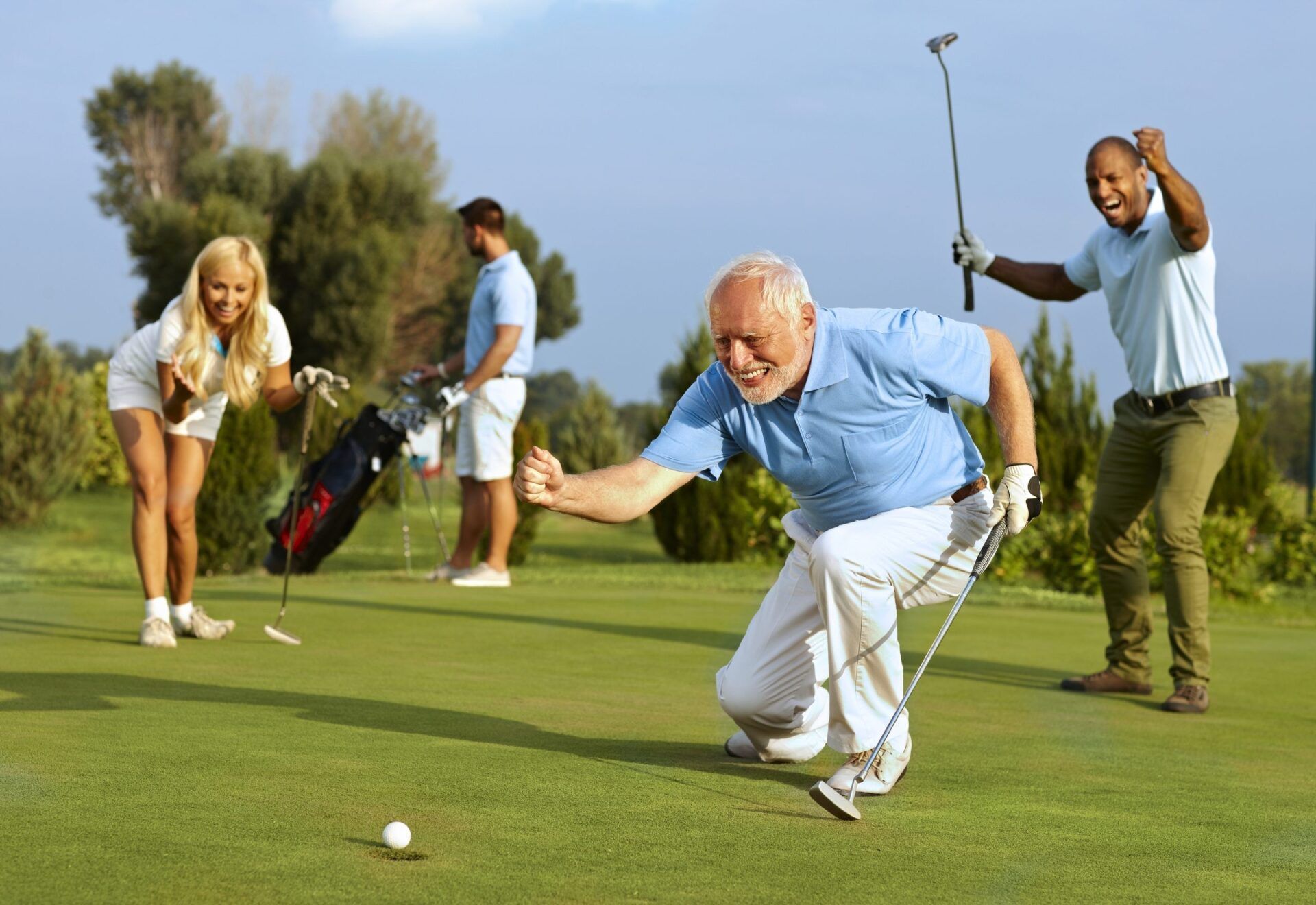 Excited golfer celebrates a successful shot on a golf course, surrounded by cheering friends.