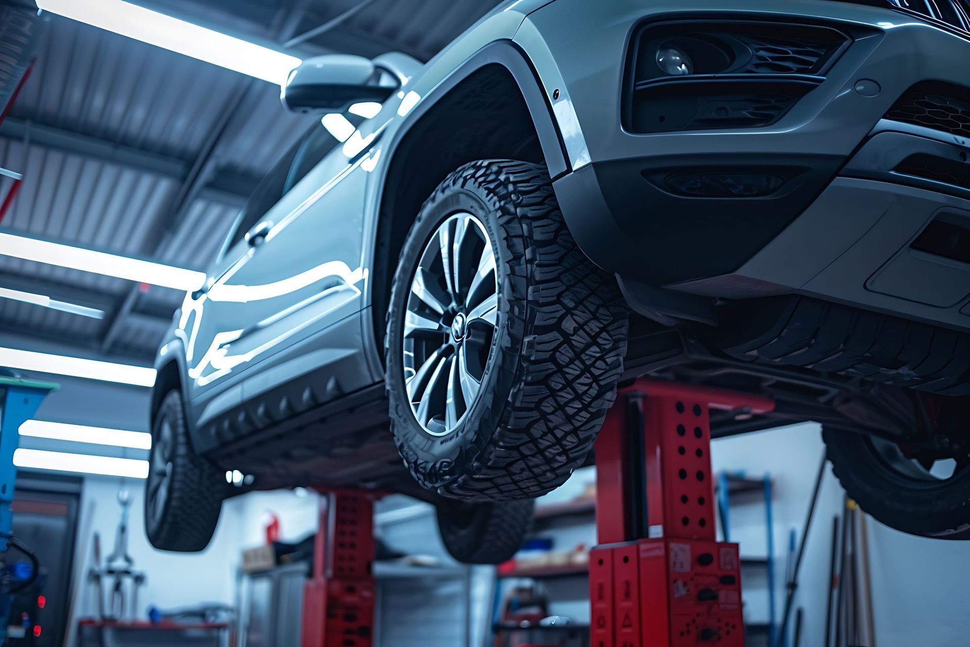A car is sitting on a lift in a garage.