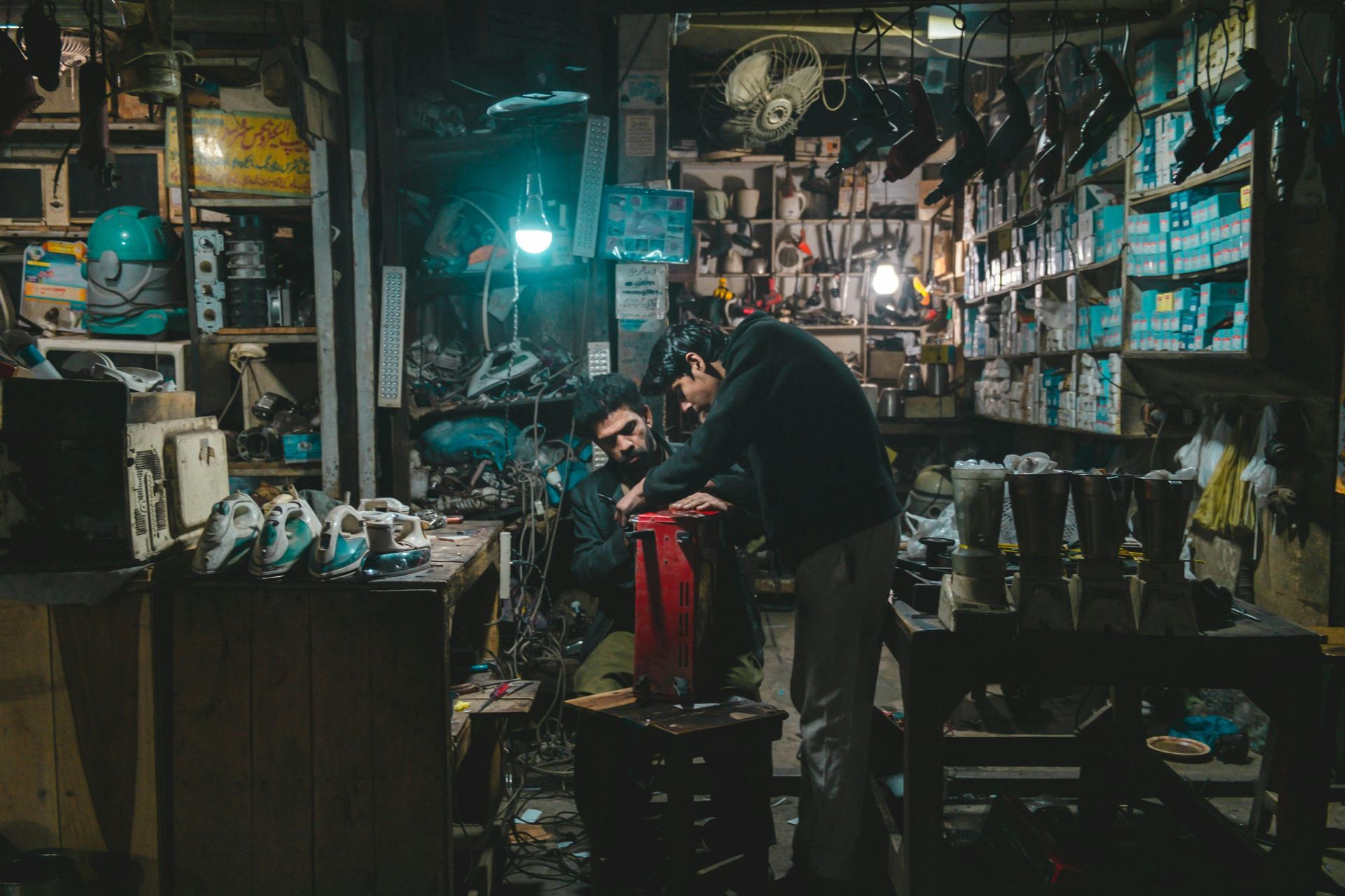 Two men are working on a motorcycle in a garage. 