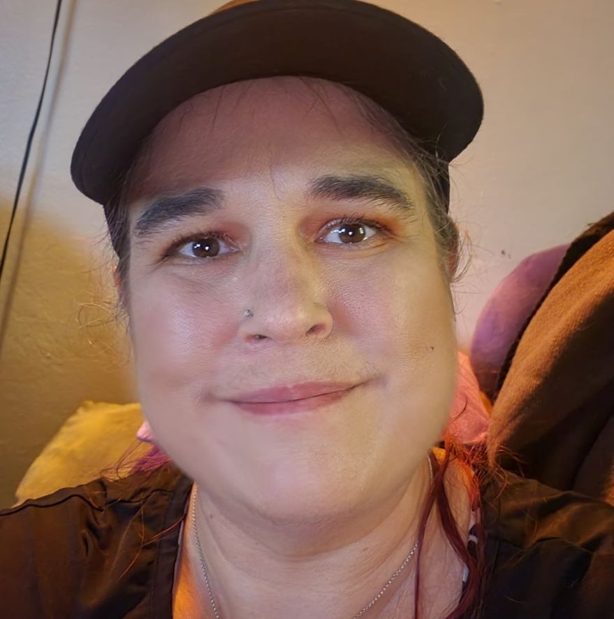 A close up of a woman wearing a hat and smiling.