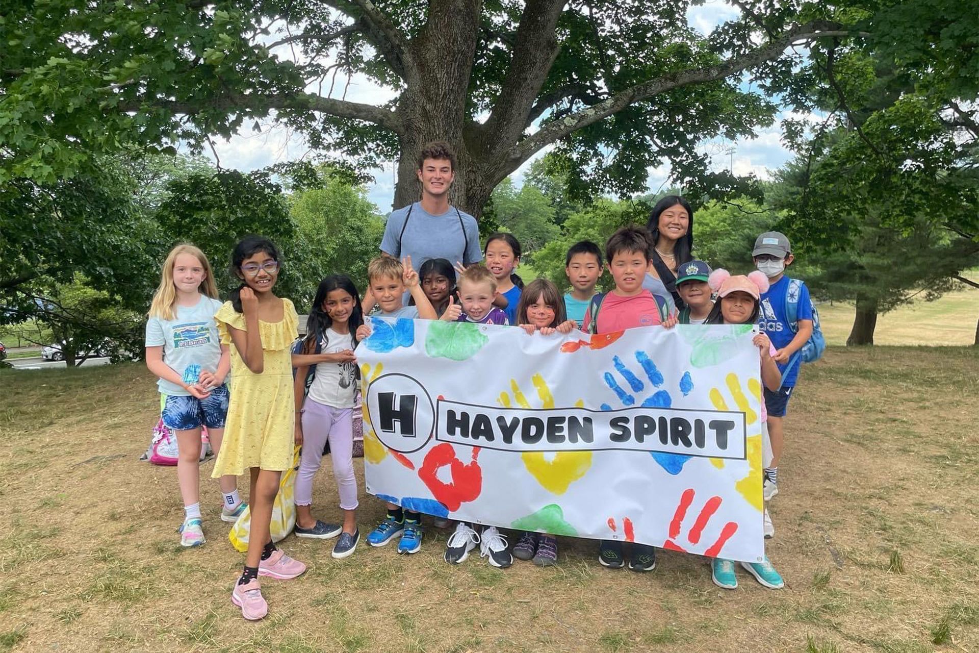 A group of children are holding a banner that says hayden spirit.