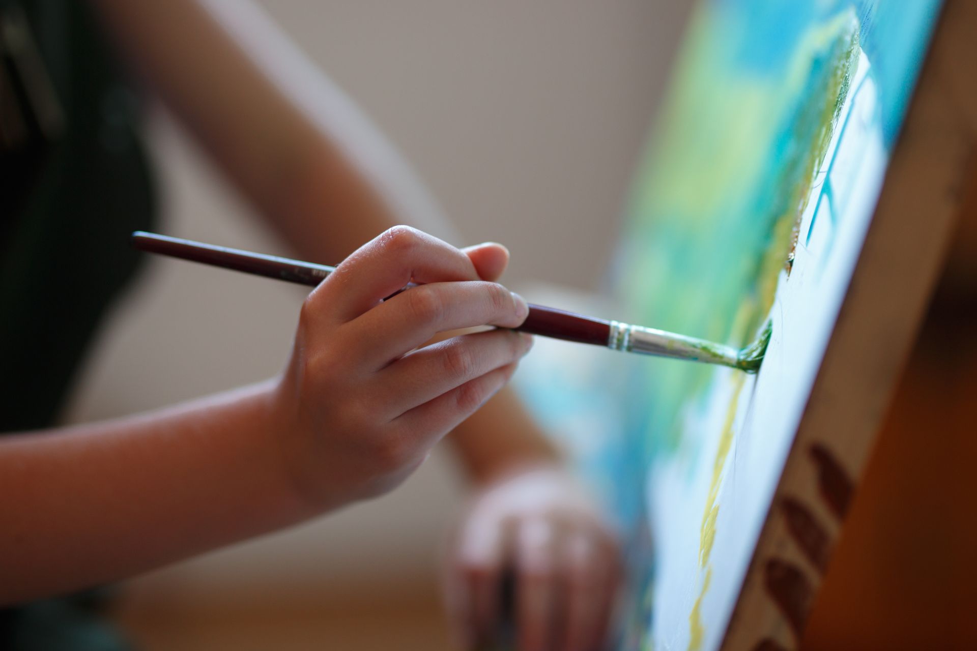 Close-up of colorful drawings scattered on a table; orange and red tones dominate.