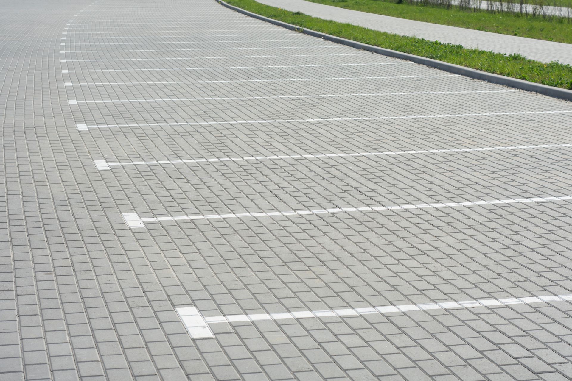Commercial parking area with durable paving stones and clearly marked parking spaces. Commercial parking area with durable paving stones and clearly marked parking spaces.