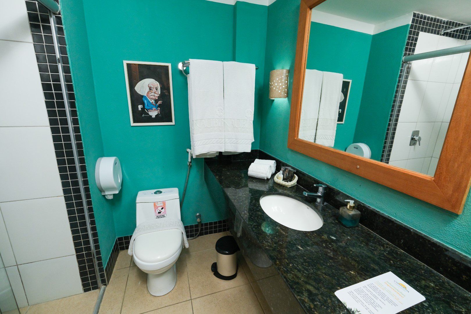 Um banheiro com um vaso sanitário, uma pia e um espelho
