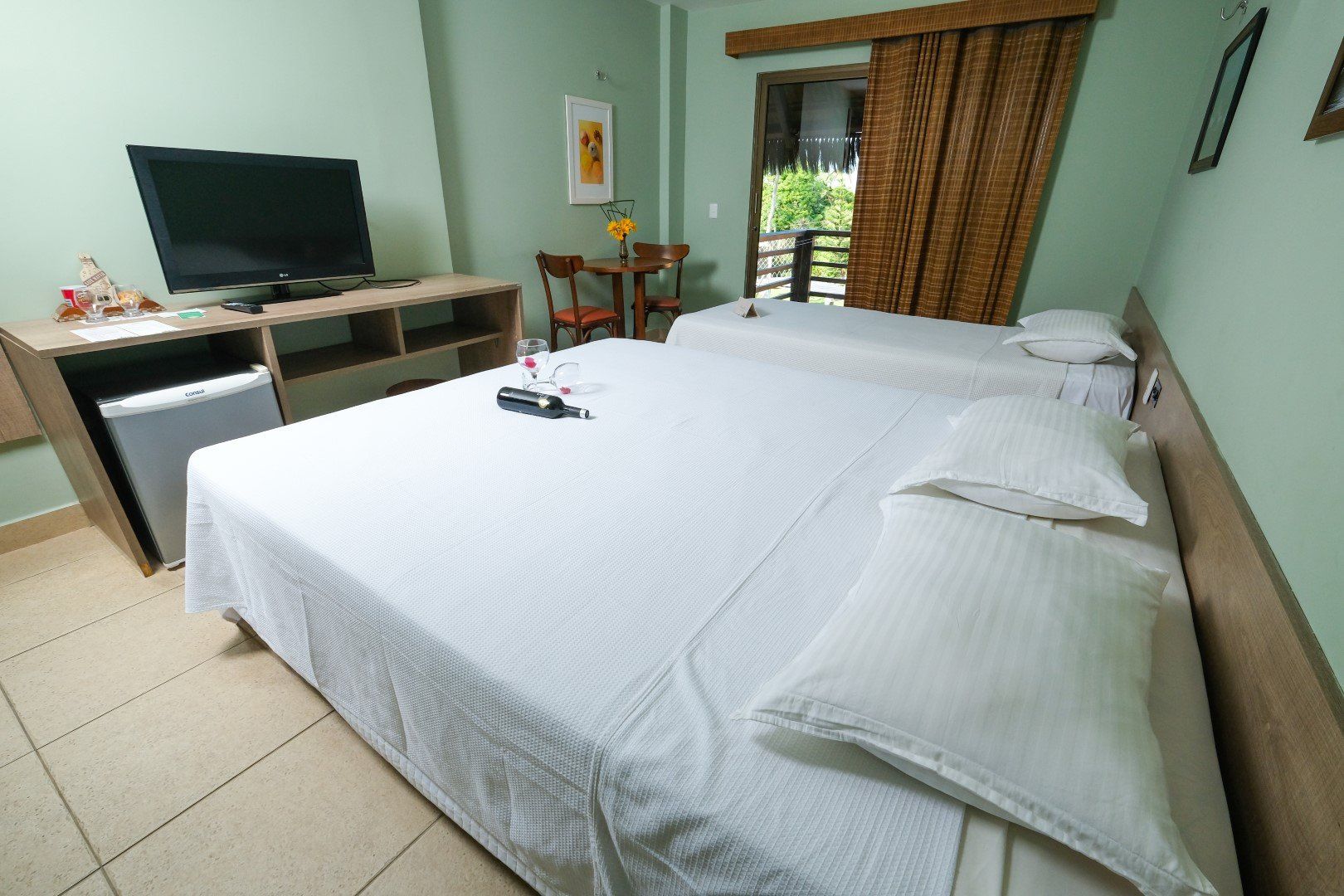 Um quarto de hotel com duas camas e uma TV de tela plana
