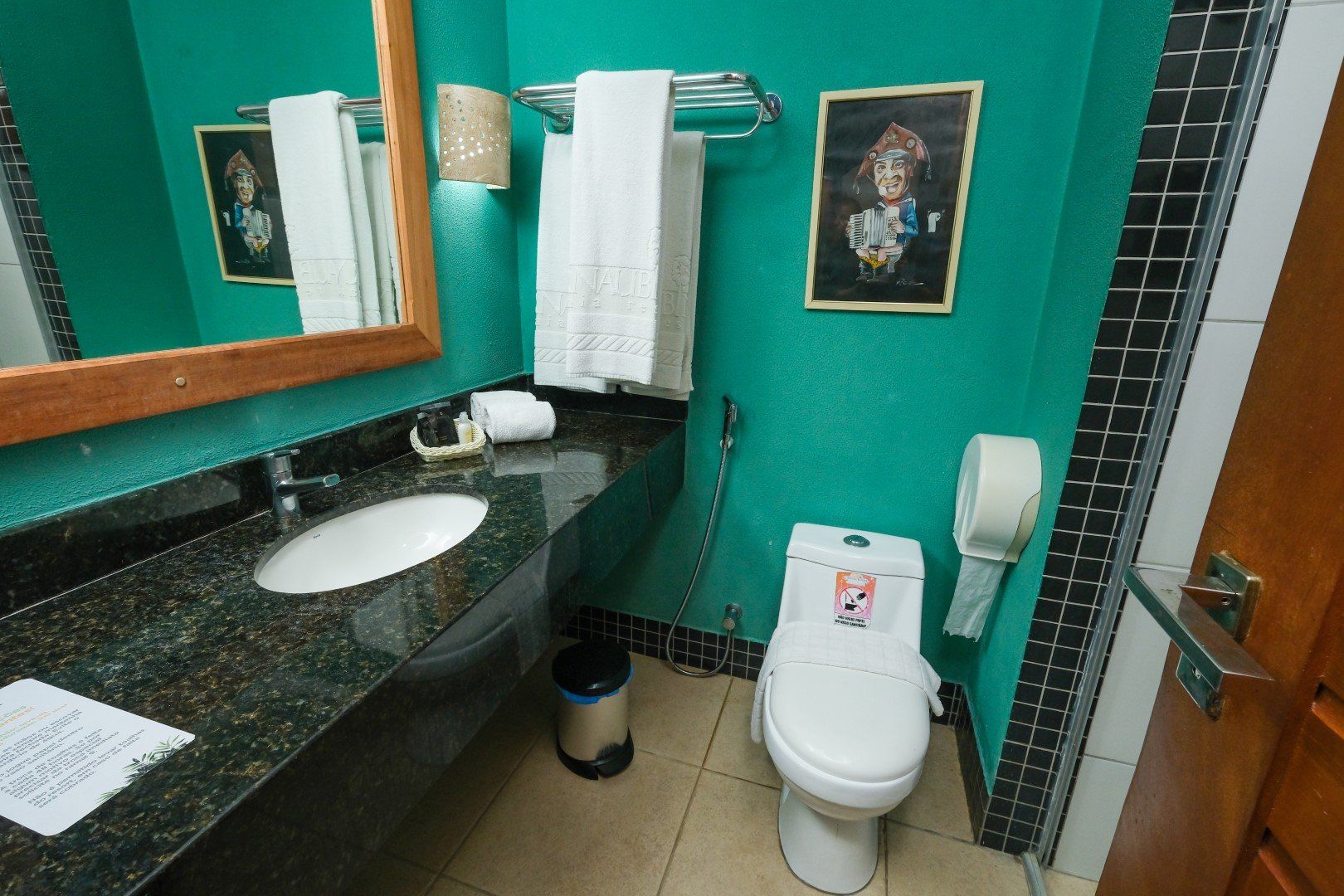 Um banheiro com um vaso sanitário, uma pia e um espelho
