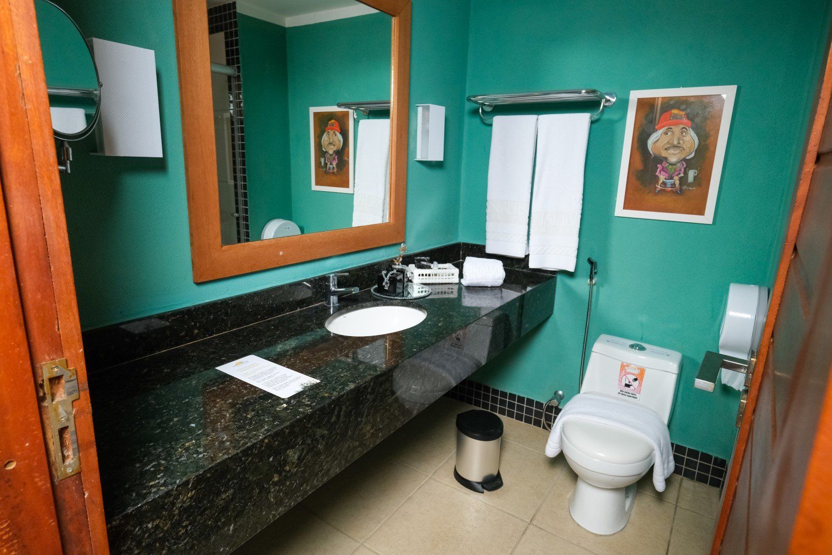 Um banheiro com um vaso sanitário, uma pia e um espelho
