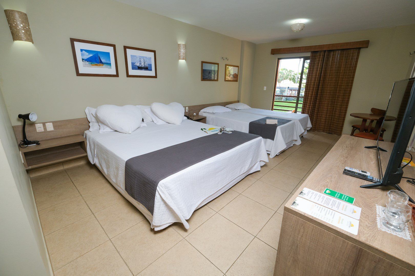 Um quarto de hotel com duas camas e uma TV de tela plana.