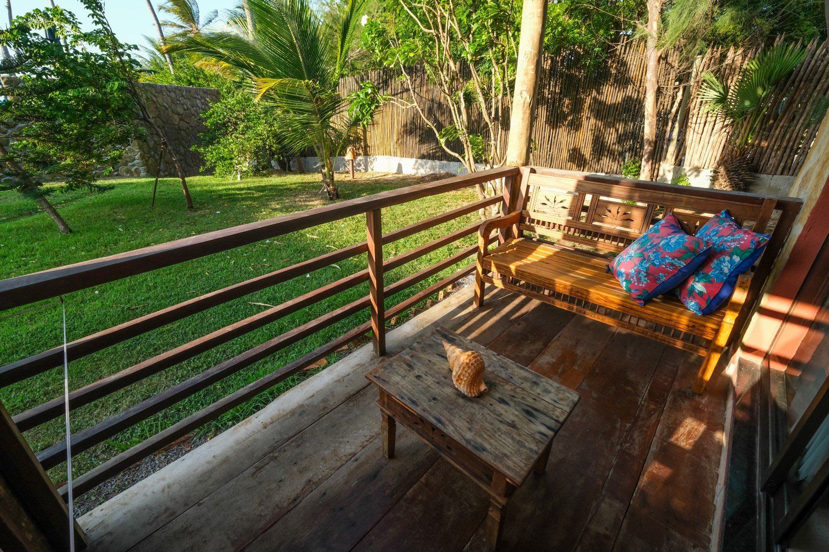 Uma varanda com um banco de madeira e uma mesa de madeira.