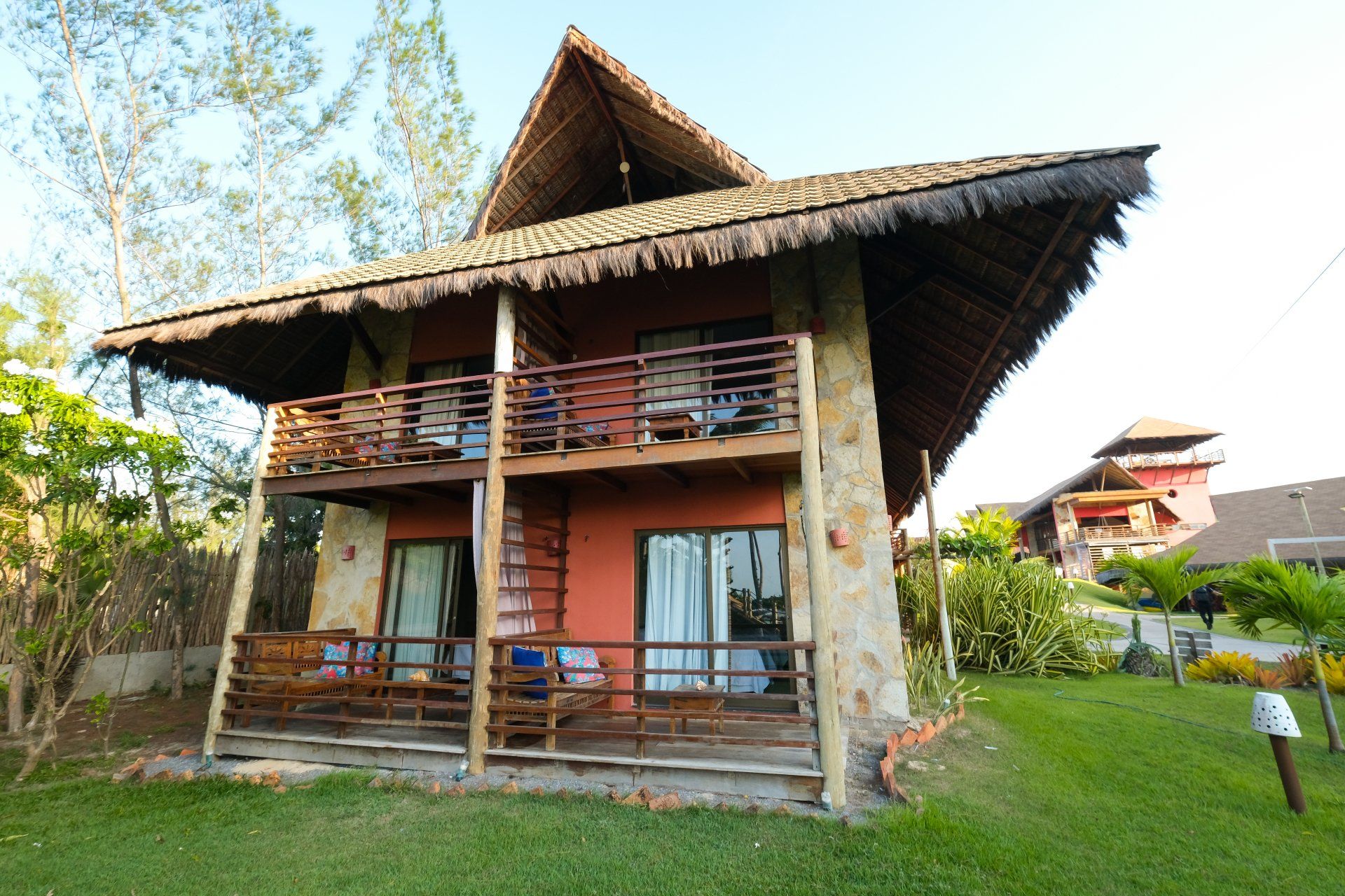Uma casa com telhado de palha e varanda