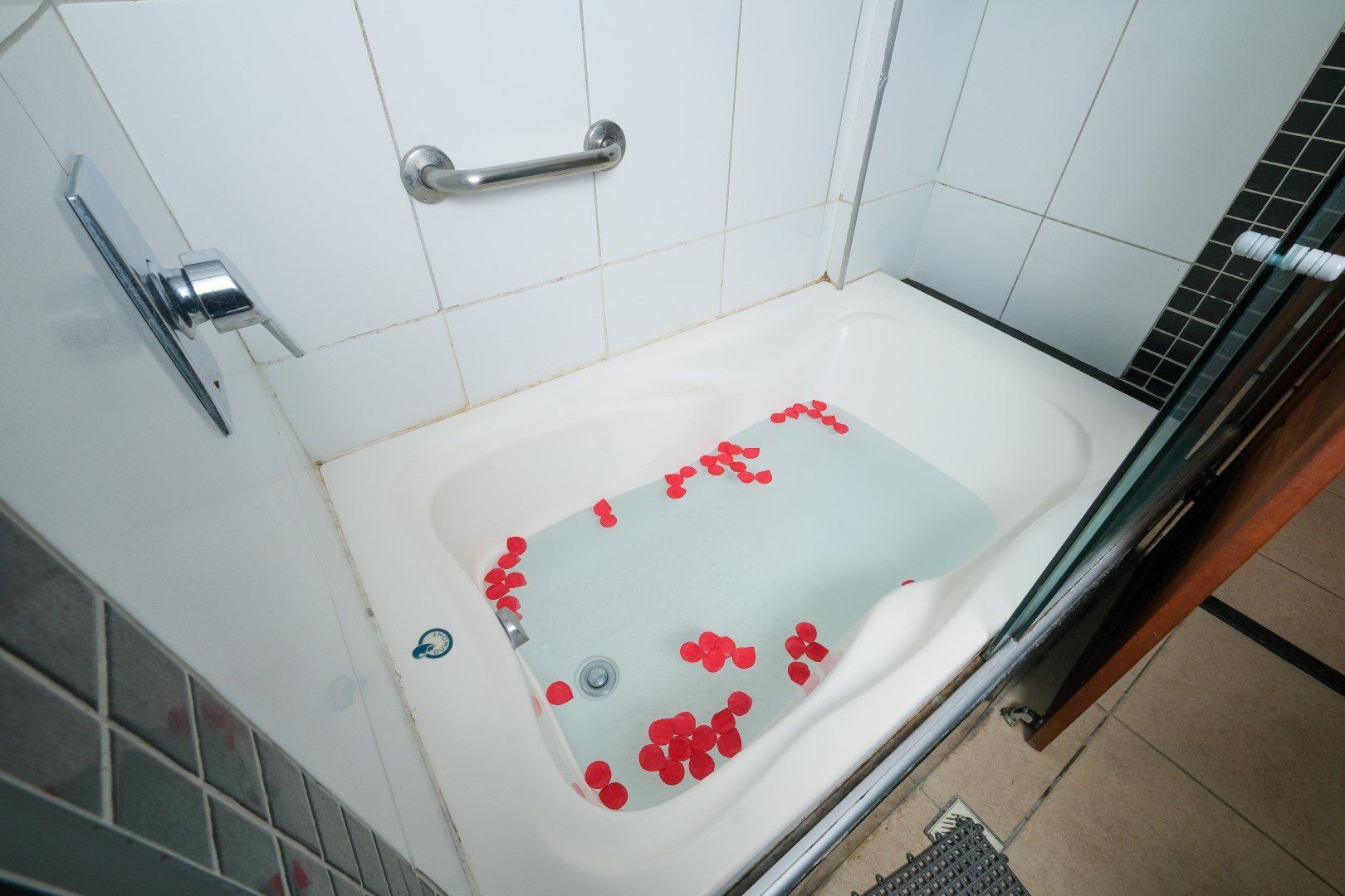 Uma banheira cheia de água e pétalas de rosa em um banheiro
