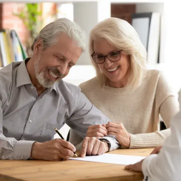 An image showing a senior couple discussing final expense insurance with a financial advisor.