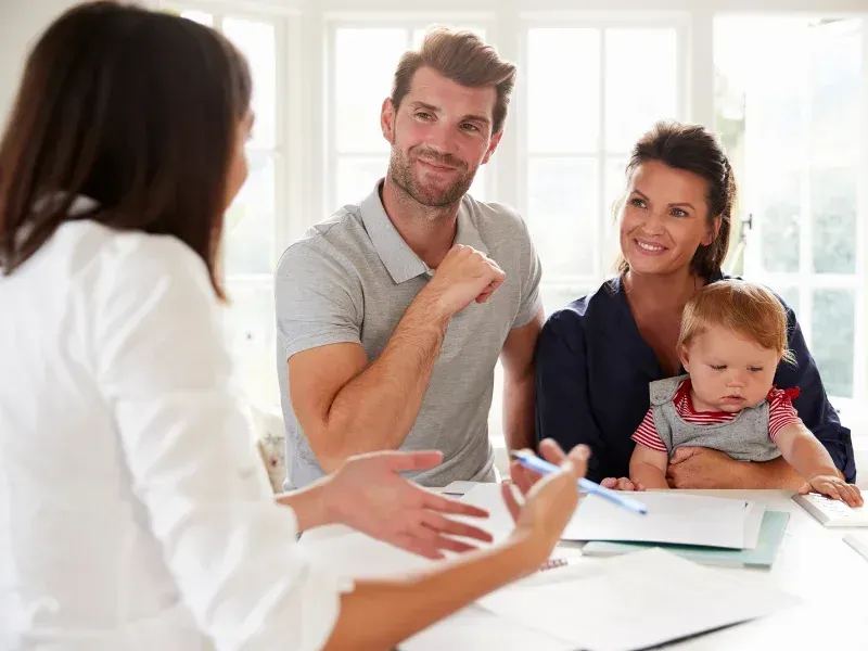 An image showing a happy family in South Carolina discussing whole life insurance options with an advisor.