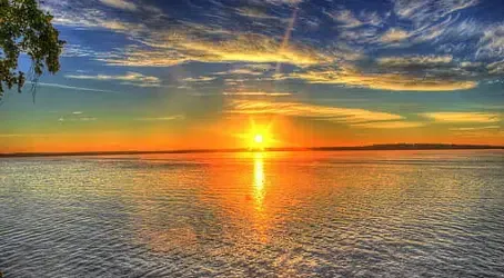 The sun is setting over a large body of water.