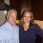 A man and a woman are posing for a picture in a kitchen.