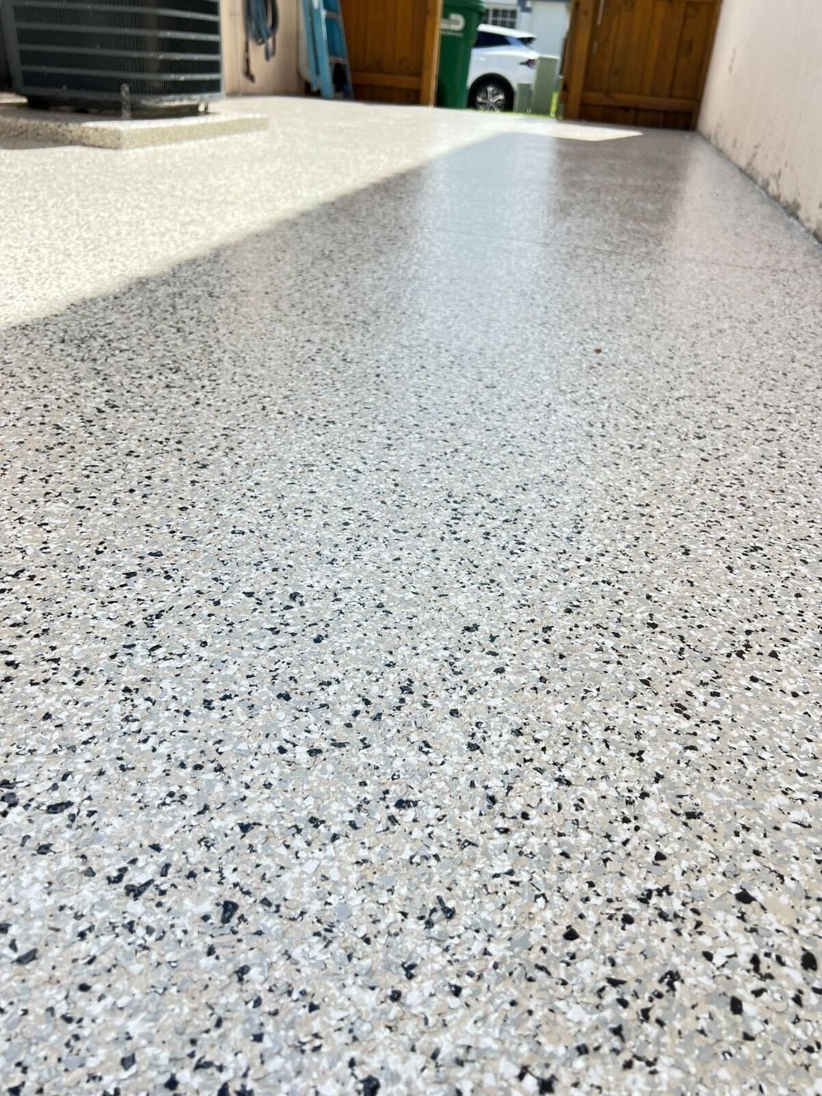 Speckled white and gray floor leading toward a room with doors and a basket in the background