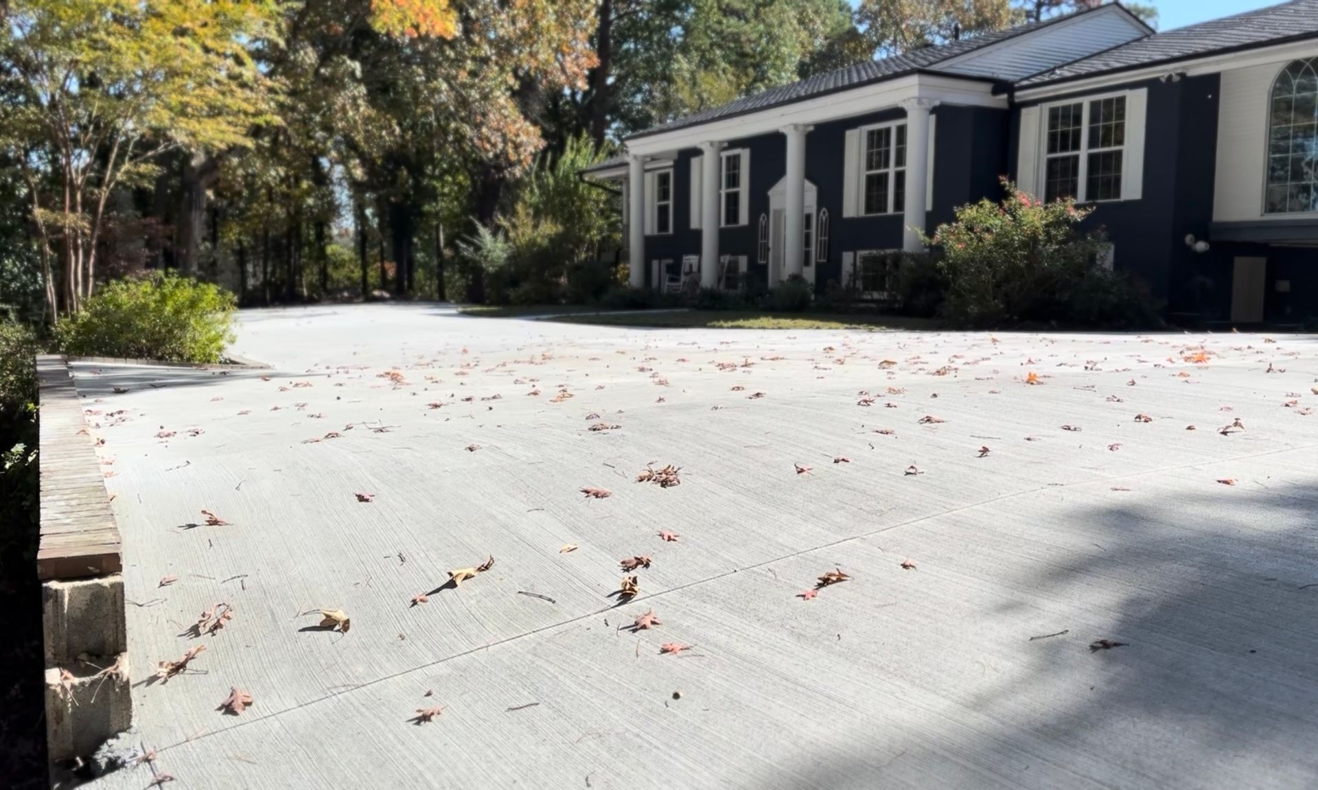 A large house with a lot of leaves on the ground in front of it