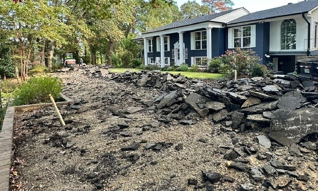 A large pile of rocks is in front of a house.