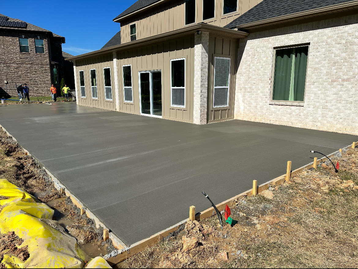 A concrete driveway is being built in front of a house.