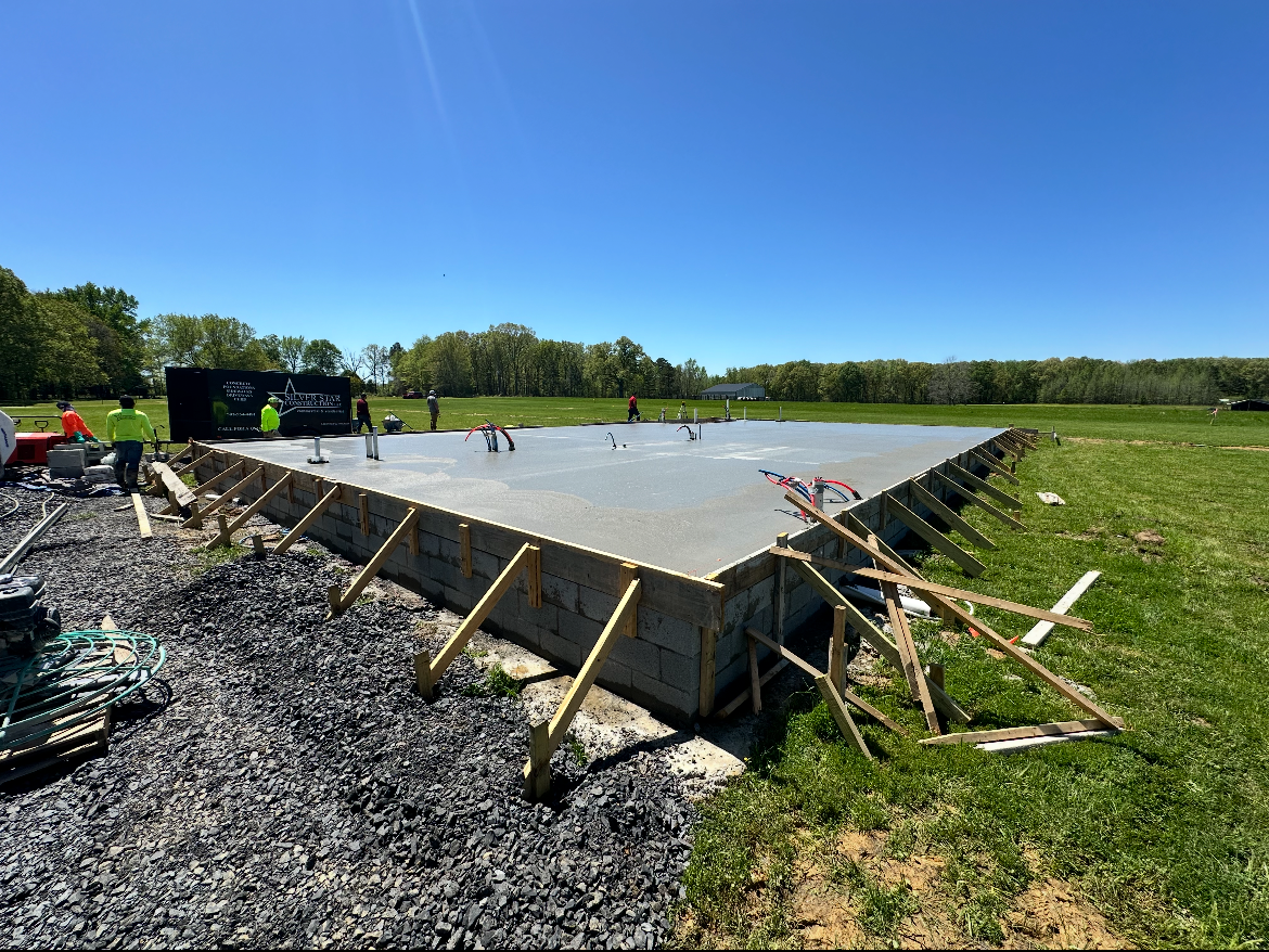 A large concrete slab is sitting in the middle of a grassy field.