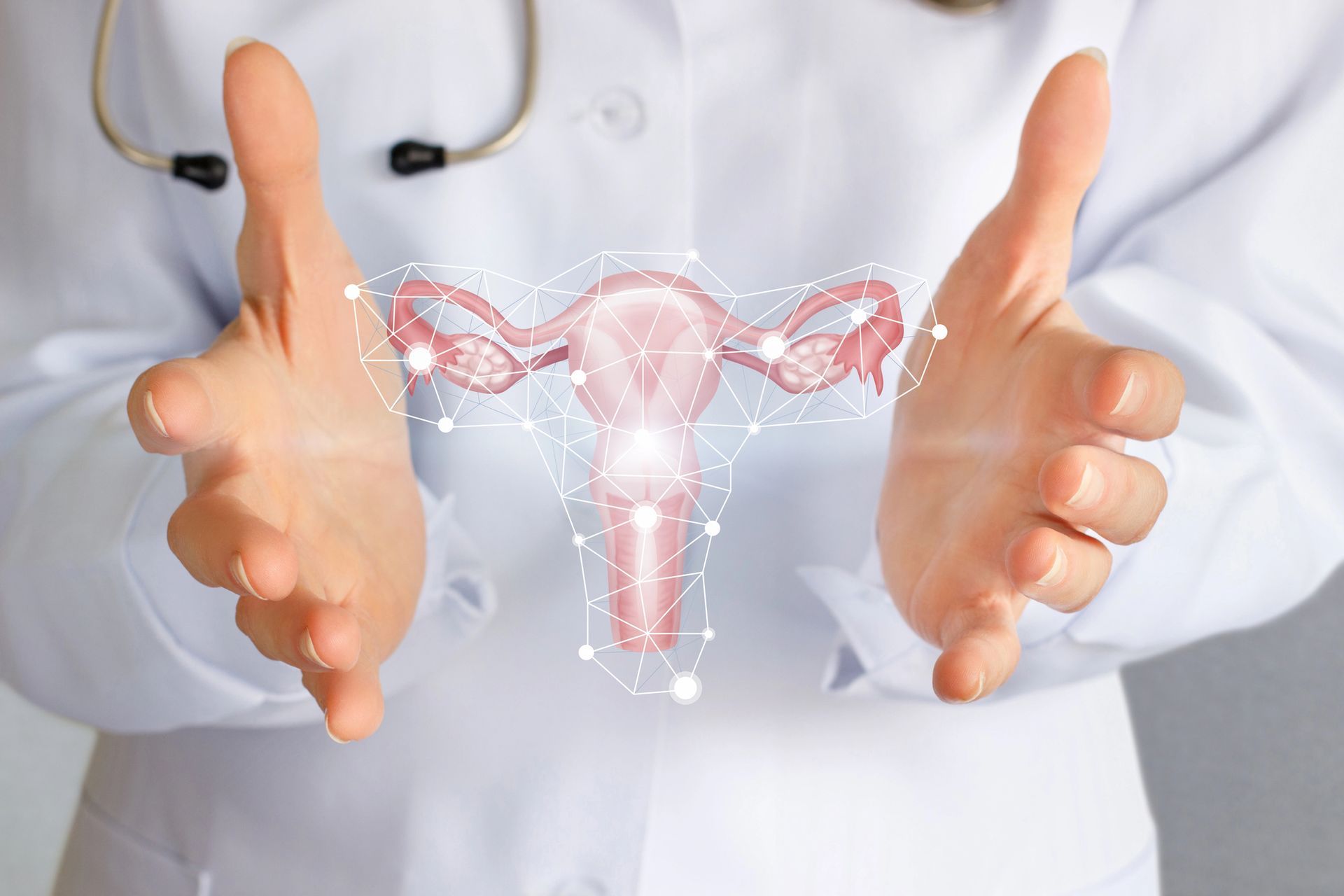 Un medico mostra un ologramma dell'apparato riproduttivo femminile sopra un camice bianco.