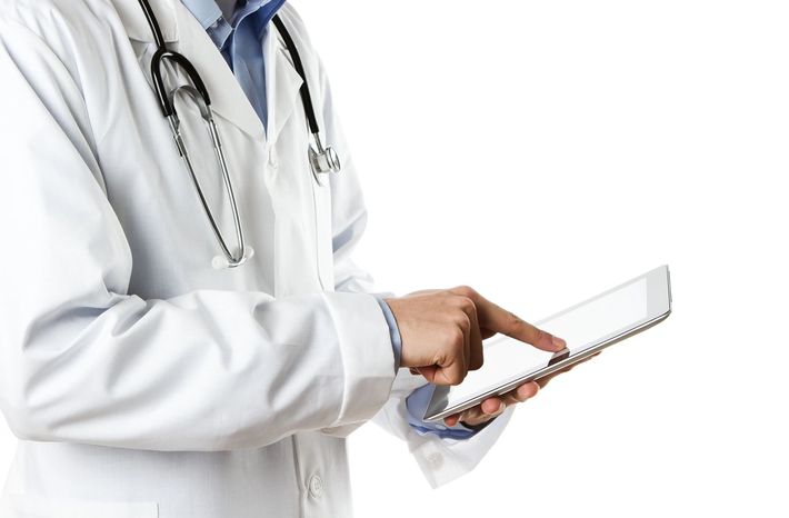 Dottore in camice bianco che usa un tablet con uno stetoscopio al collo
