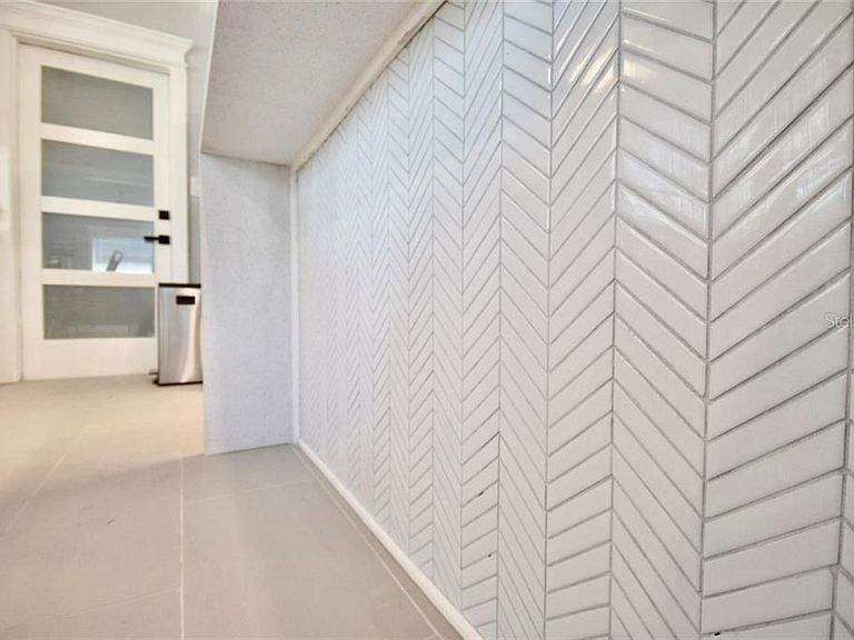 A hallway with a herringbone pattern on the wall.