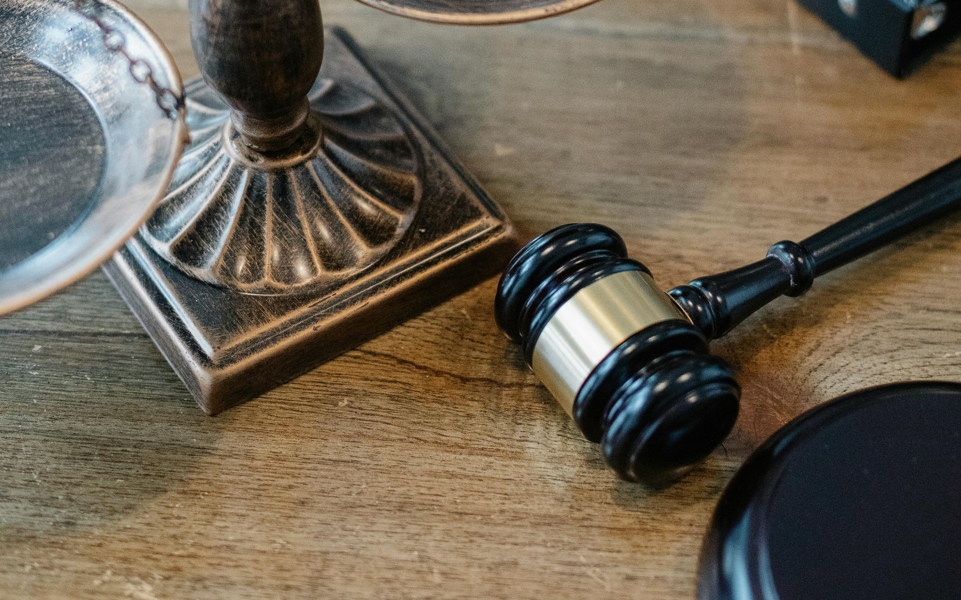Scales of justice and a gavel on a wooden table, symbolizing law and legal proceedings.