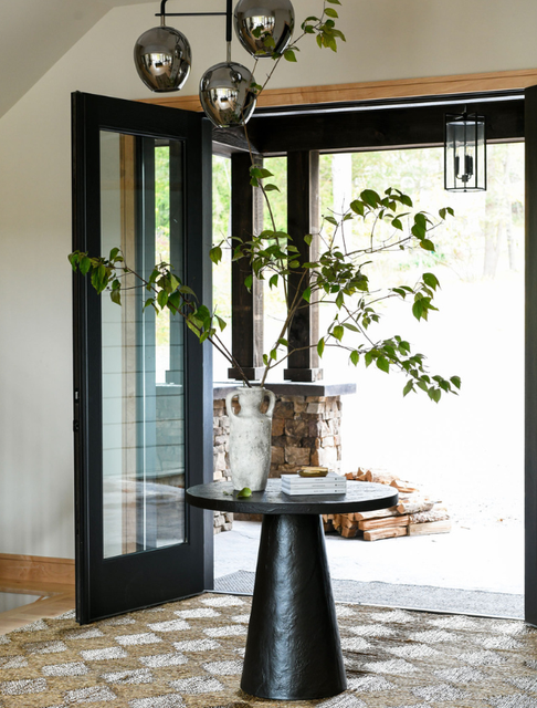 Open entryway with vase and books on black end table