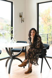 Liz Brooks sitting down on a chair at a table