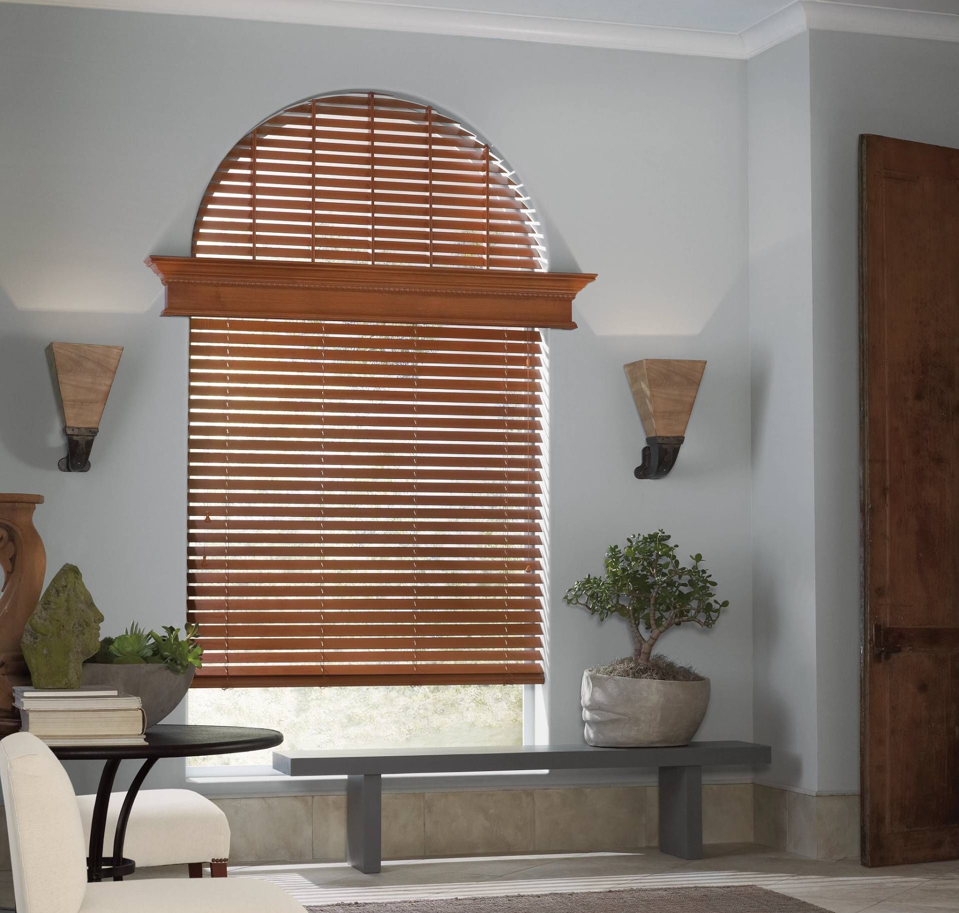 Hunter Douglas Parkland® Wood Blinds covering an arched living room window.