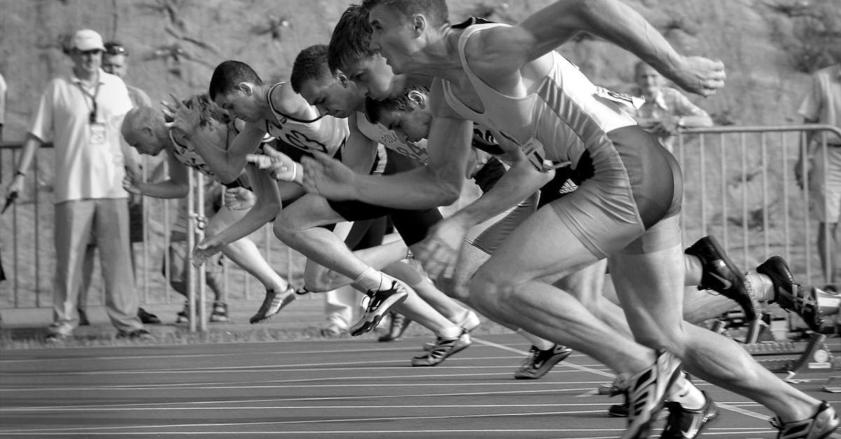 A black and white photo of a group of men running on a track.
