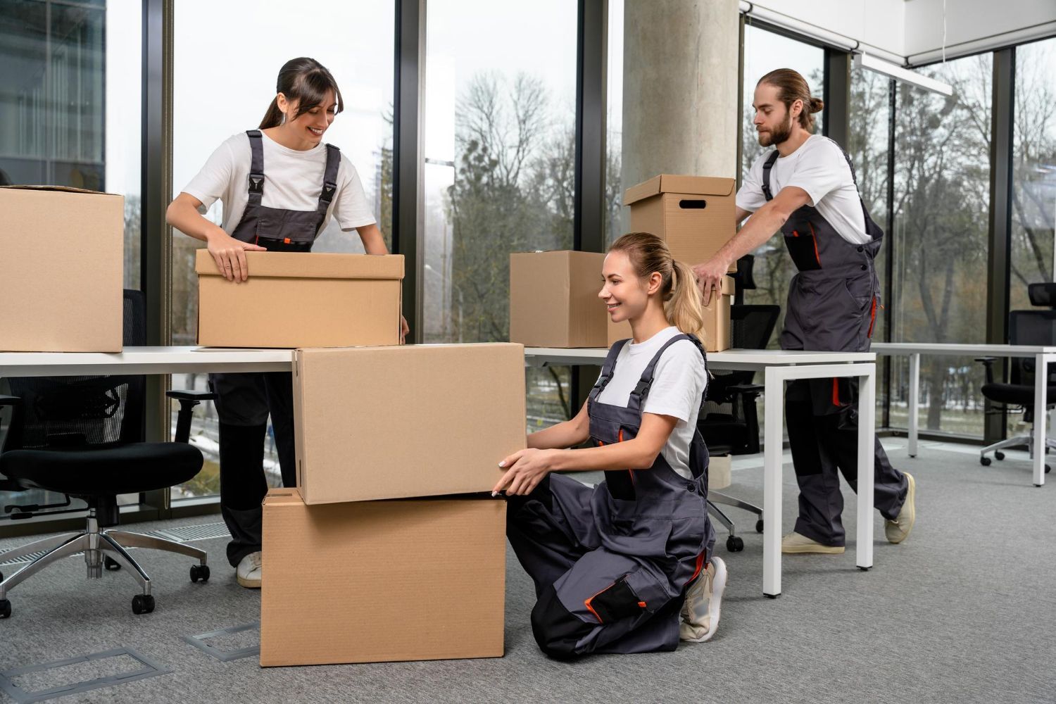 Team of coworkers moving boxes in a bright office during a relocation.