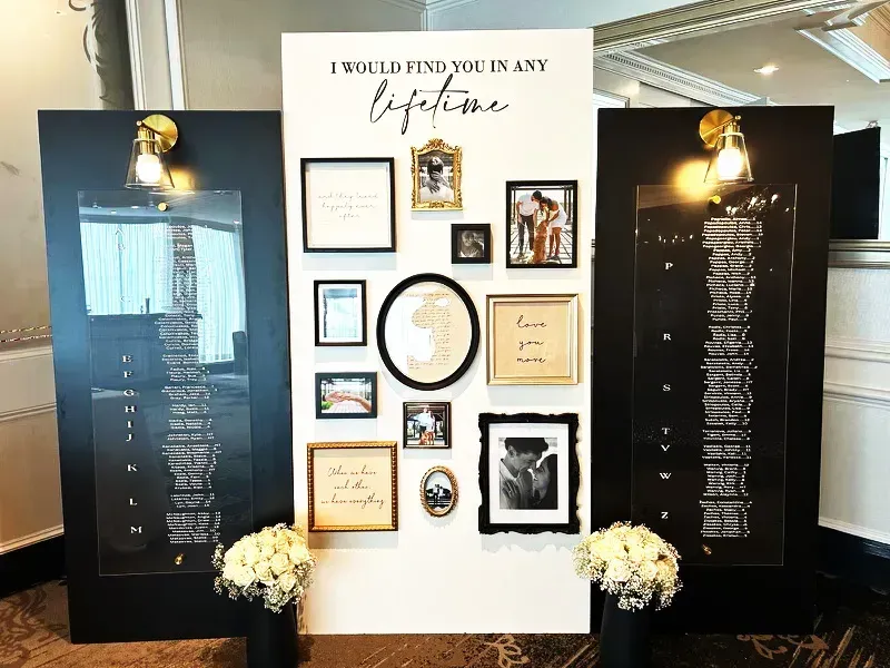 Elegant black-and-white gallery wall with framed photos, quotes, and decor in a living room