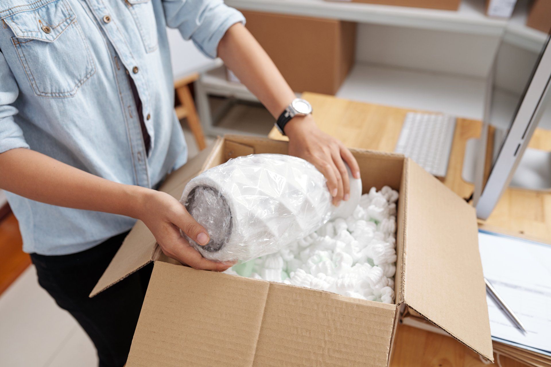 Packing a glass item in bubble wrap into a cardboard box