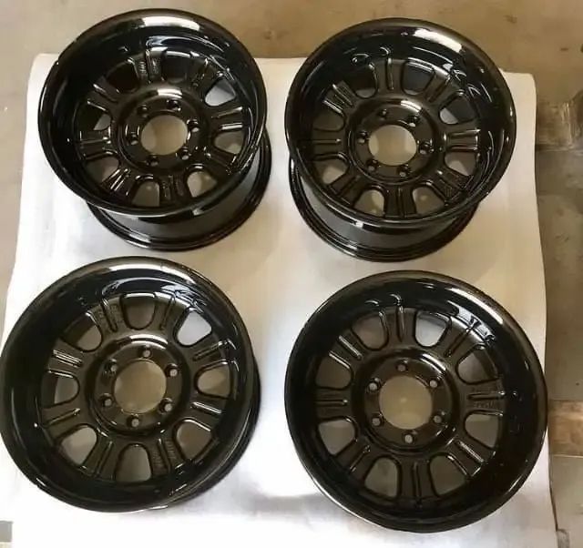 Four Black Rims Are Sitting On A White Surface — Hunter Powder & Paints In Newcastle, NSW