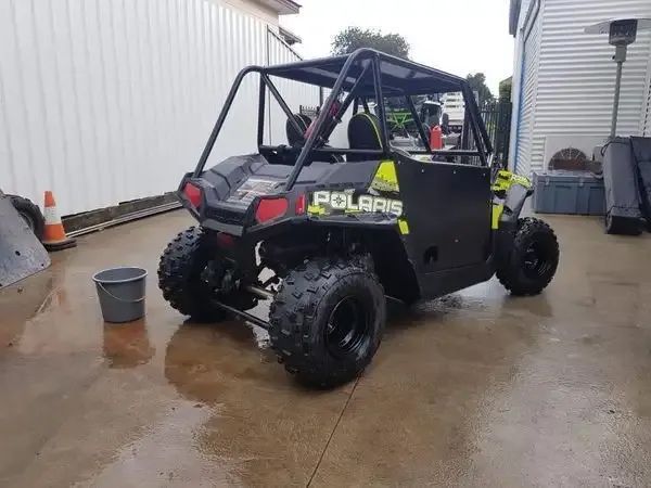A Black Polaris Atv Is Parked In A Parking Lot — Hunter Powder & Paints In Port Stephens, NSW
