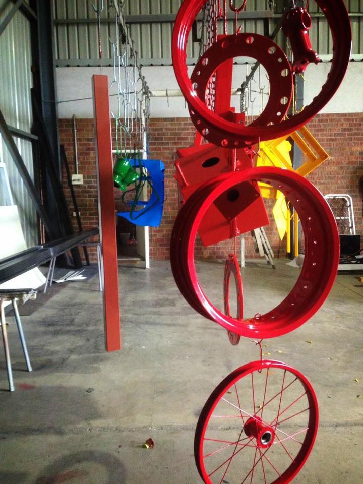 A Bunch Of Red Wheels Are Hanging From The Ceiling — Hunter Powder & Paints In Mid North Coast, NSW