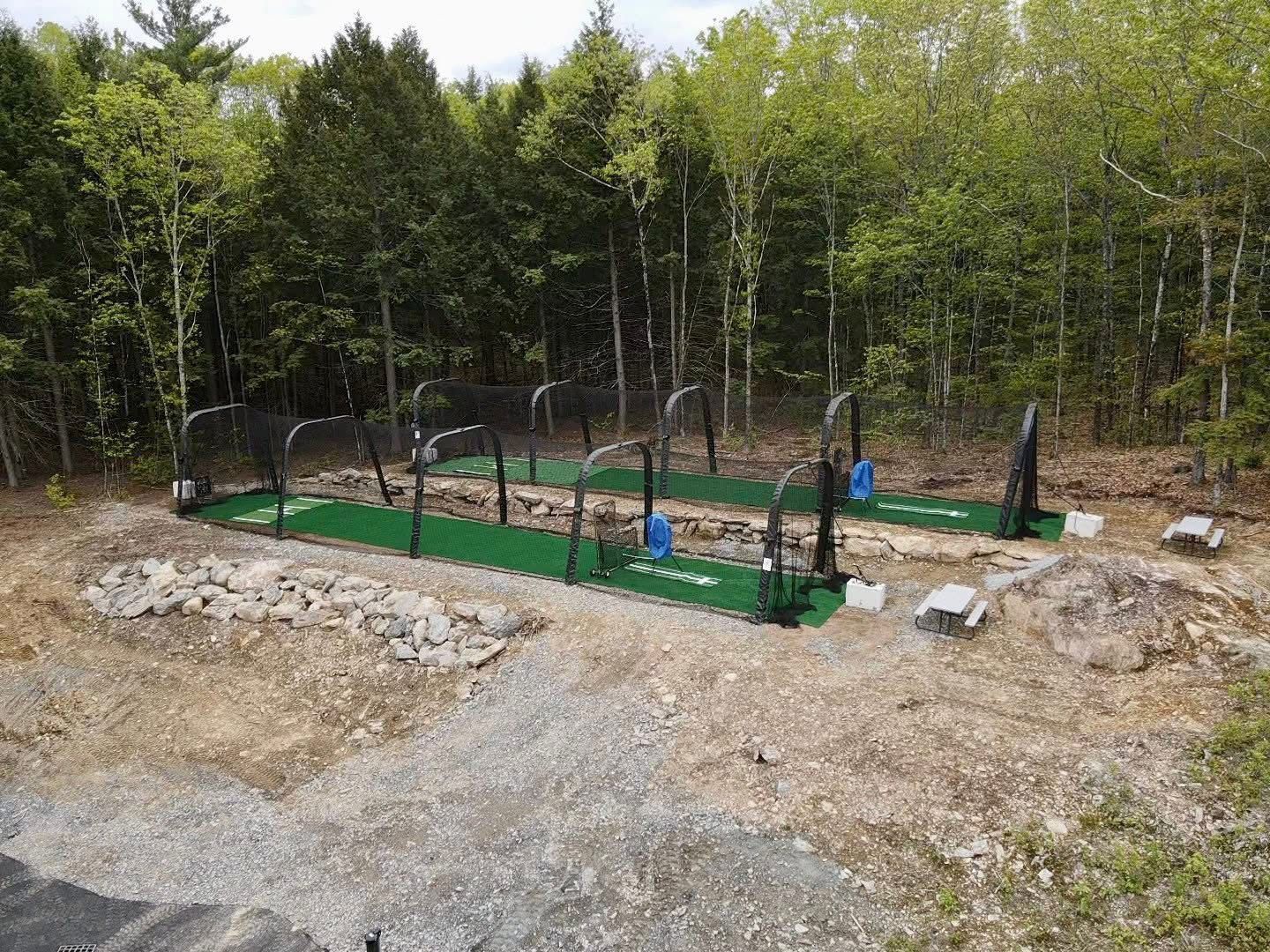 An aerial view of a golf course in the middle of a forest.