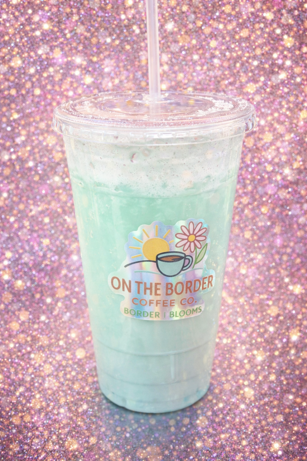 Mint green blended drink in clear plastic cup with straw, 